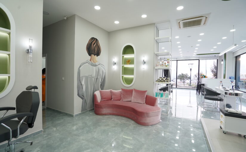 Eleganter Wartebereich im Bahar Babacan Beauty Center mit rosa Designer-Sofa und moderner Studioeinrichtung.