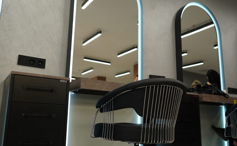 Moderne Beautysalon Innenarchitektur in Wien mit LED Spiegeln, Friseurstuhl und individuell geplanter Saloneinrichtung.
