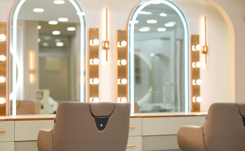 Exklusive Friseureinrichtung mit modernen Stylingplätzen, beleuchteten Spiegelstationen und maßgefertigten Salonmöbeln.