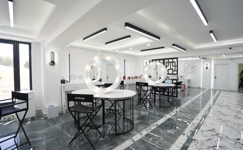 Heller Friseursalon mit luxuriöser Stylinginsel, runden Spiegeln und hochwertiger Innenarchitektur