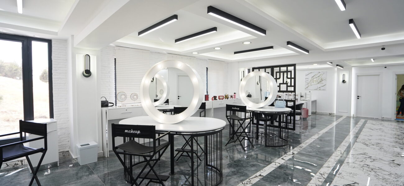 heller-friseursalon-mit-runden-spiegeln-und-stylinginsel.jpg Heller Friseursalon mit luxuriöser Stylinginsel, runden Spiegeln und hochwertiger Innenarchitektur