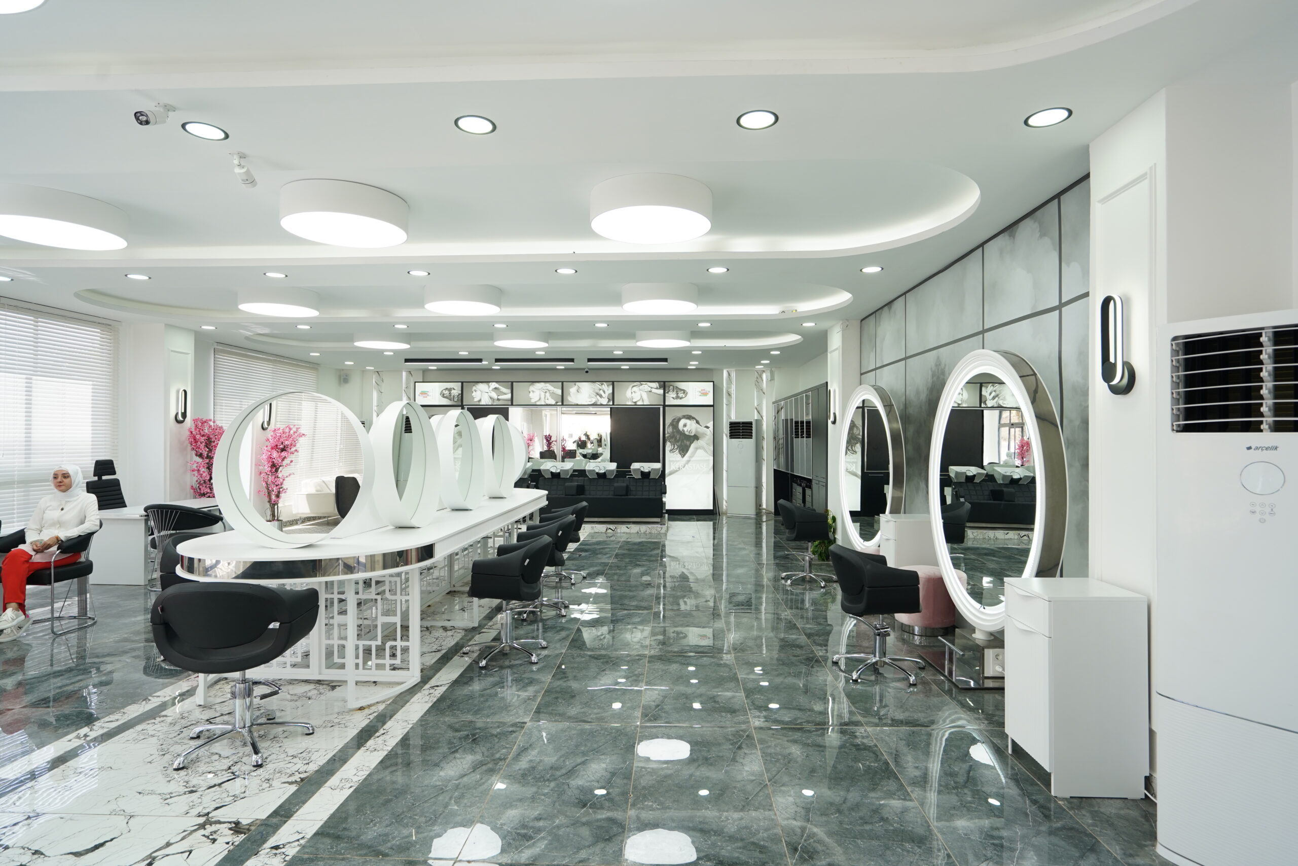 moderner-friseursalon-stylingbereich-mit-runden-spiegelplaetzen.jpg Moderner Friseursalon mit runden Spiegelplätzen, luxuriösem Innenausbau und stilvoller Beleuchtung
