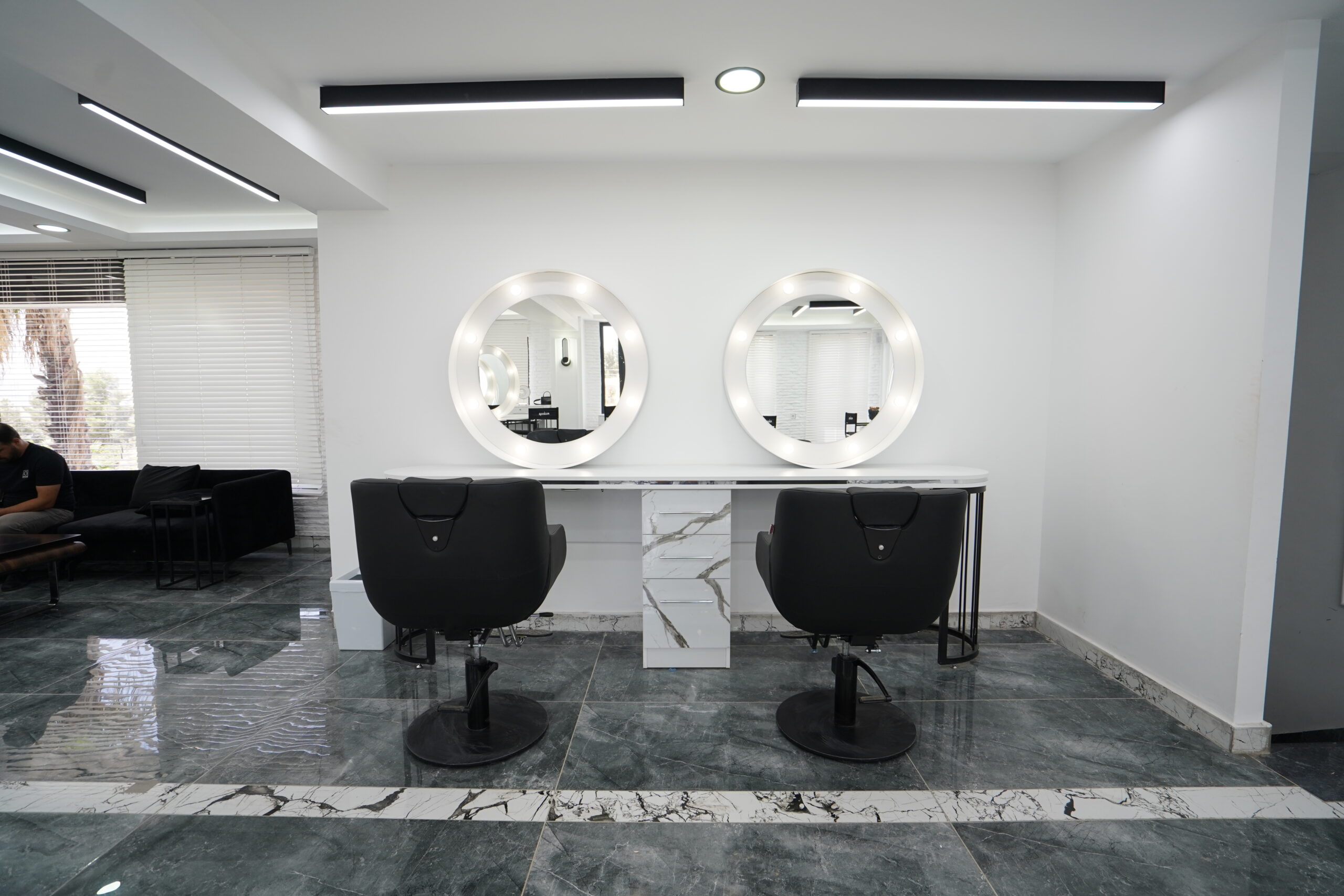 Moderner Nail und Beauty Bereich mit weißen Arbeitstischen und minimalistischer Premium Einrichtung